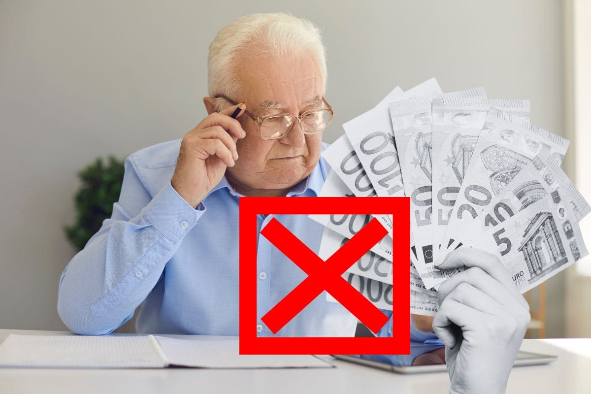 uomo anziano al telefono mentre controlla tablet, con mano in bianco e nero che tiene banconote euro e x rossa sopra