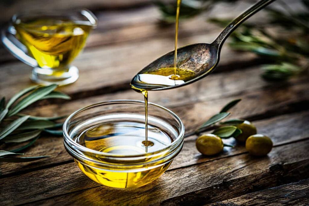 olio versato in un cucchiaino che cade in una ciotolina