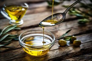 olio versato in un cucchiaino che cade in una ciotolina