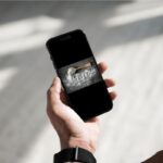 donna che tiene in mano smartphone con foto sale