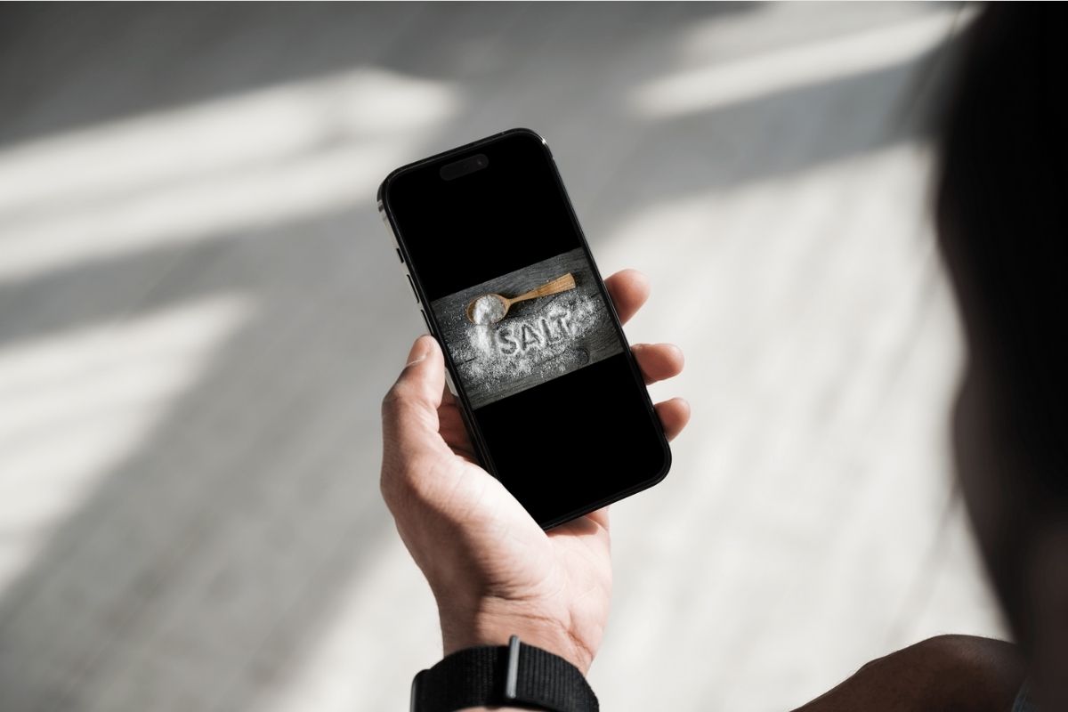 donna che tiene in mano smartphone con foto sale