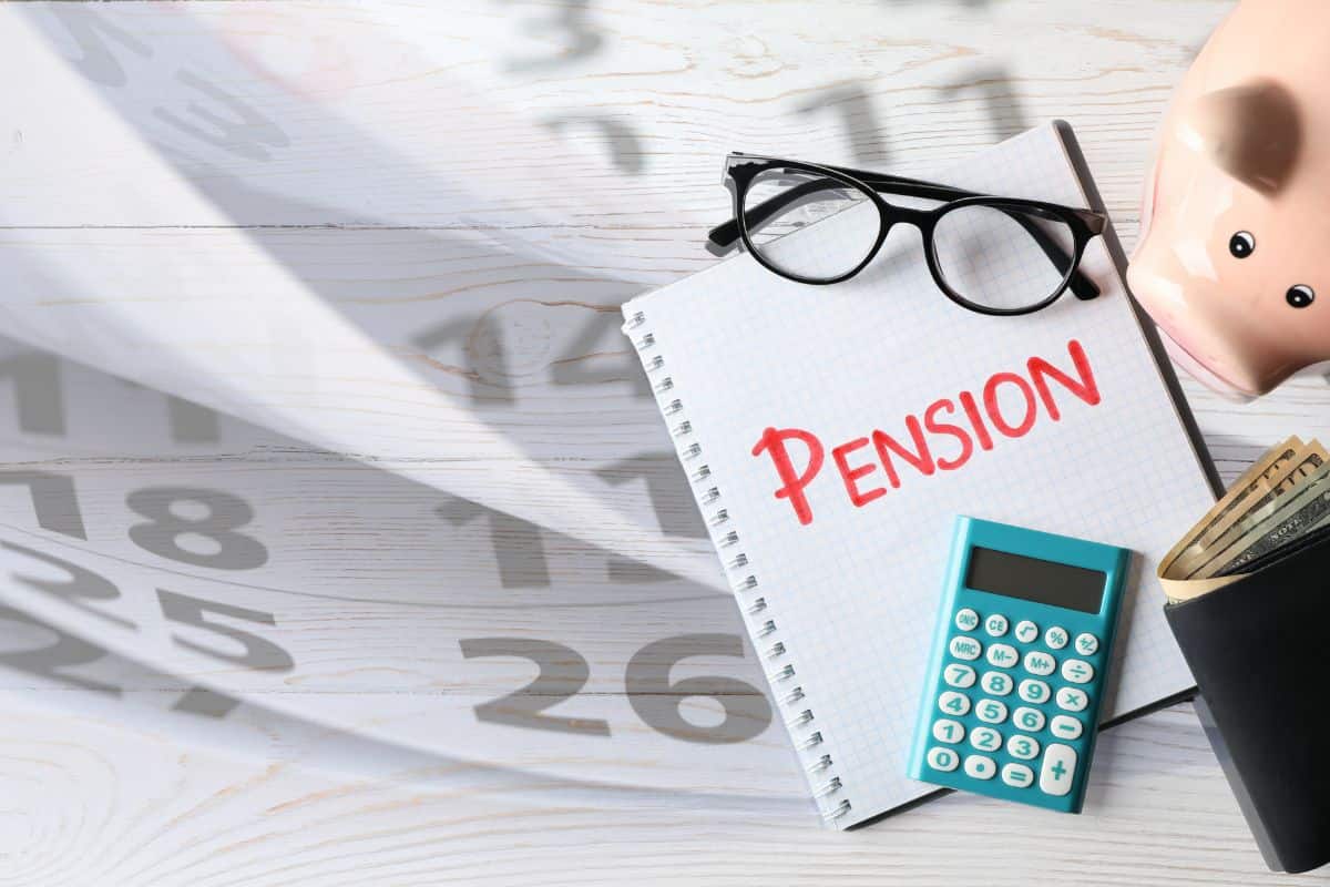 calendario con occhiali, quaderno con scritto pension, calcolatrice e maialino salvadanaio