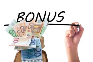 mano che scrive bonus e sacchetto con banconote euro