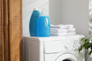 lavatrice con sopra detersivi senza etichetta e dal colore blu