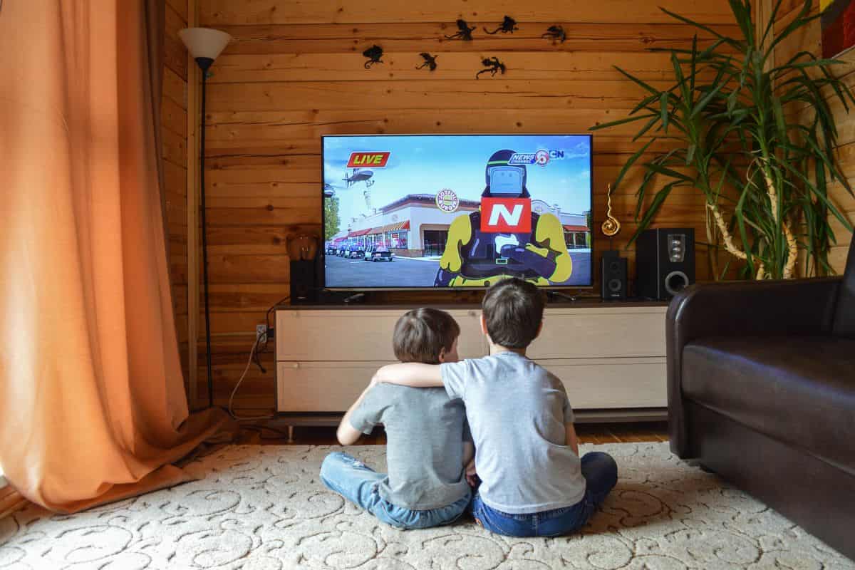 in una cameretta due bambini guardano la tv