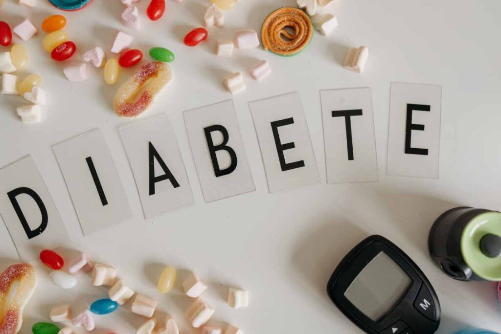 glucometro tra dolci e la scritta diabete