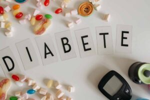 glucometro tra dolci e la scritta diabete