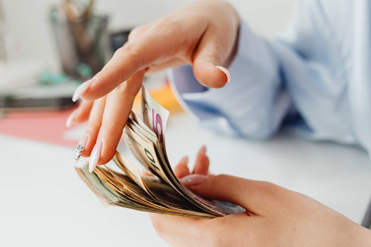 donna con soldi contanti in mano