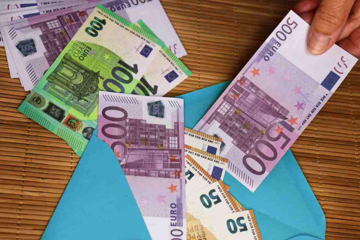 busta con soldi e mano che prende una banconota da 500 euro