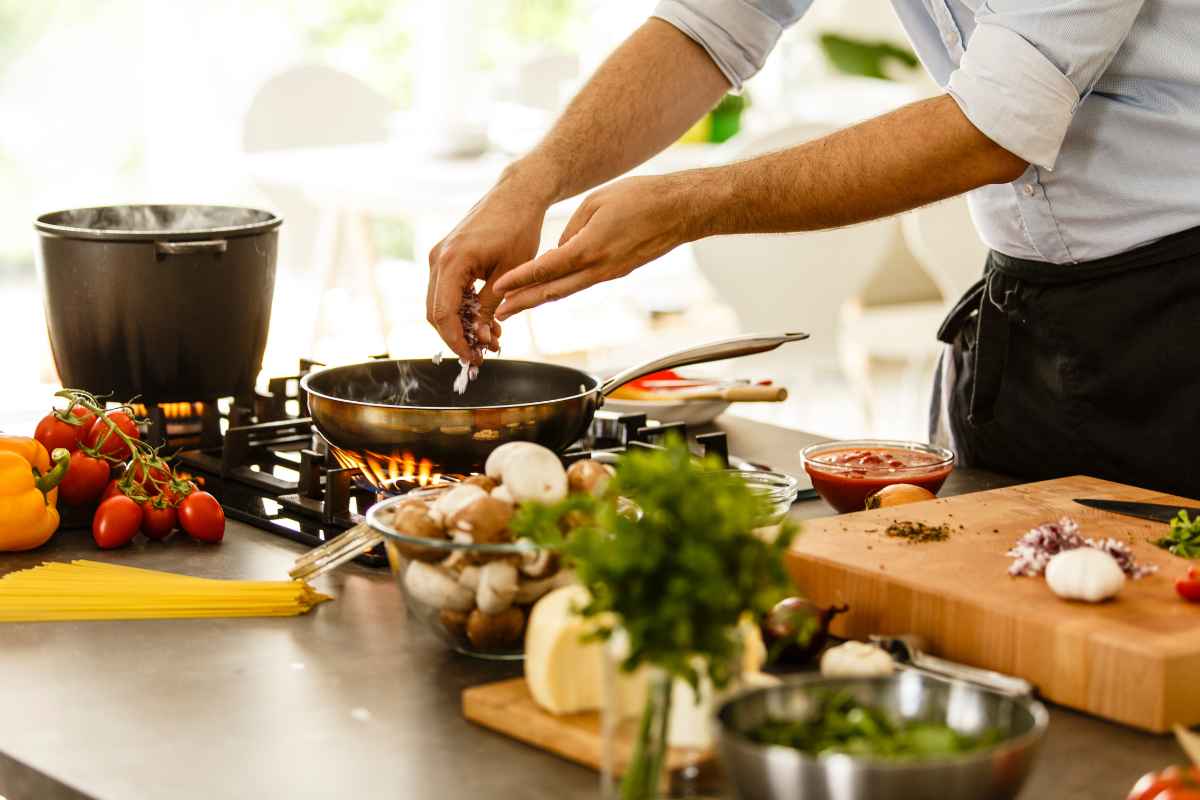 persona che cucina, sul piano della cucina diversi alimenti