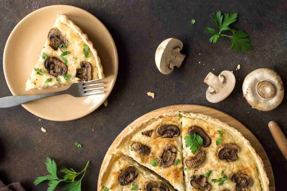 torta salata con funghi e fetta di torta salata in un piatto