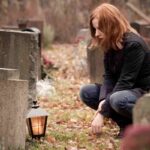 persona commossa davanti a una tomba