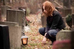 persona commossa davanti a una tomba