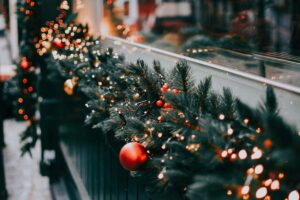 addobbo ramo sul camino con luci e palline rosse