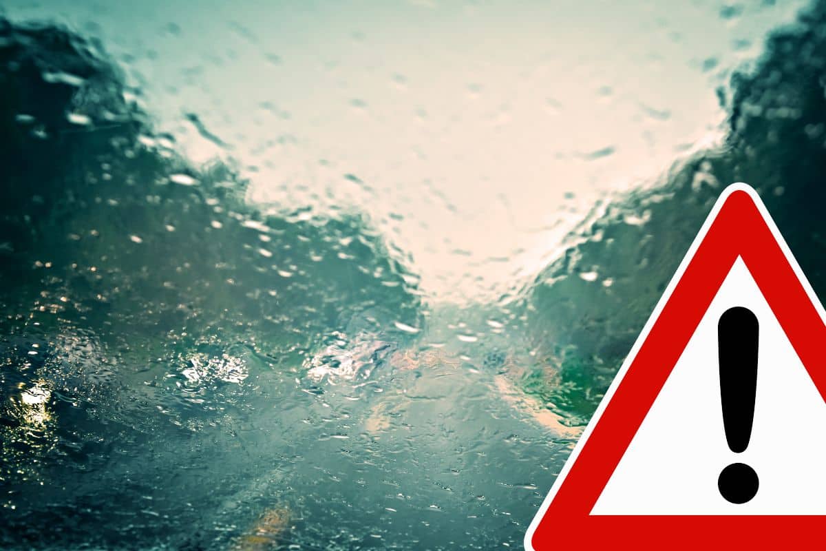 strada con temporale e cartello pericolo