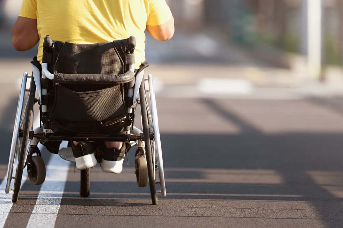persona disabile su una strada in carrozzina