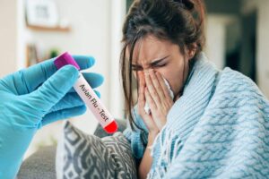 donna influenzata con mano con guanto che tiene una provetta con test aviaria