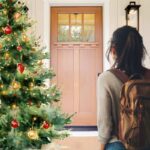 porta di casa, con donna di spalle con zaino pronta alla partenza e albero di natale