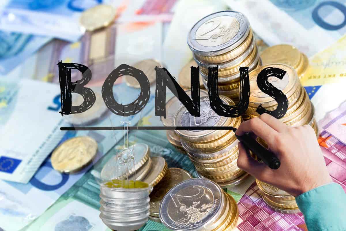 banconote euro, mano che scrive bonus e lampadina