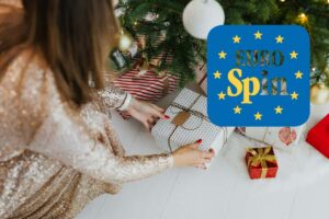 donna che mette pacchetto regalo natale sotto l'albero e logo eurospin