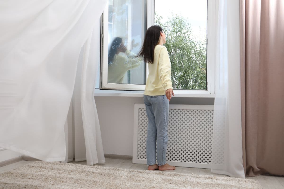 donna che apre finestra casa