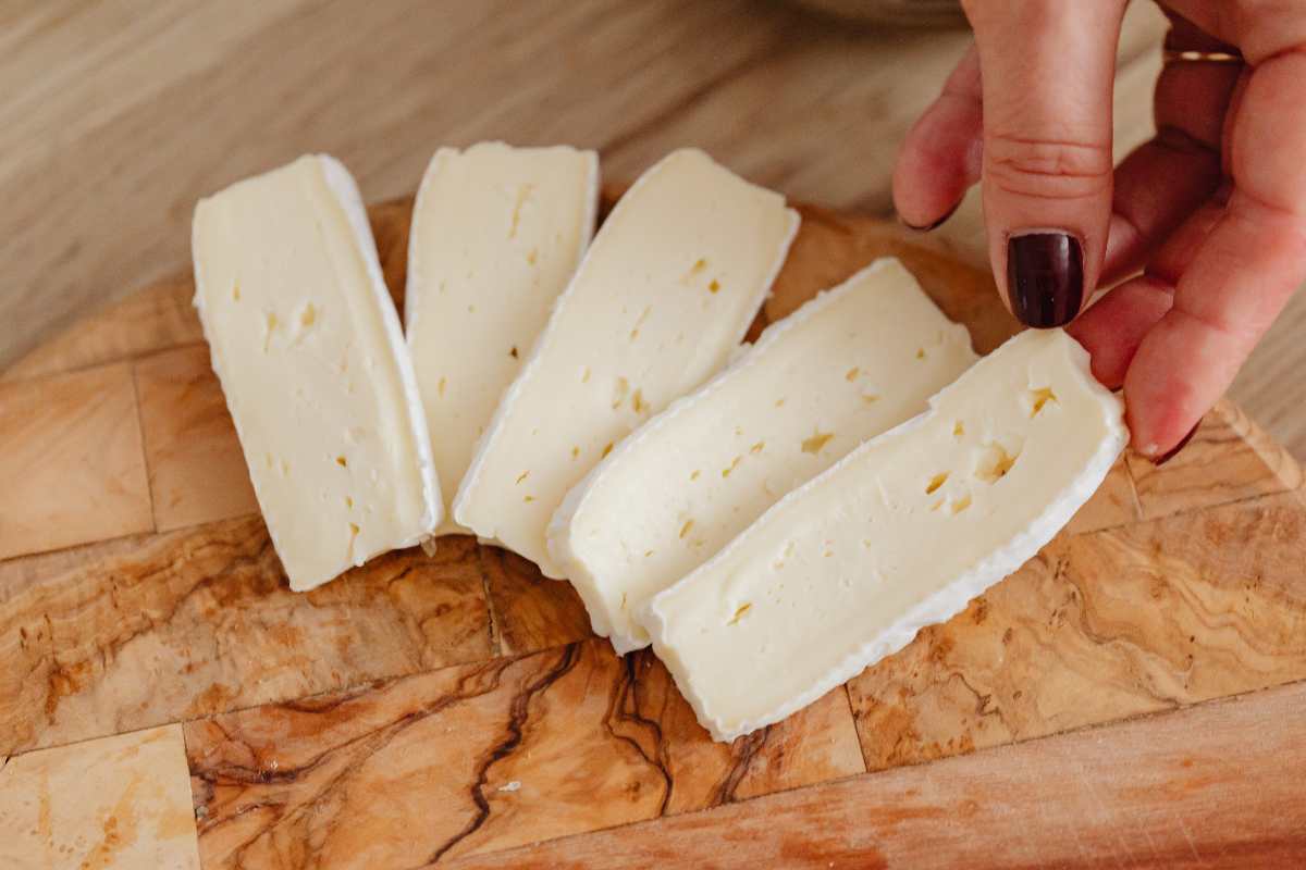 persona che sistema formaggio su tagliere