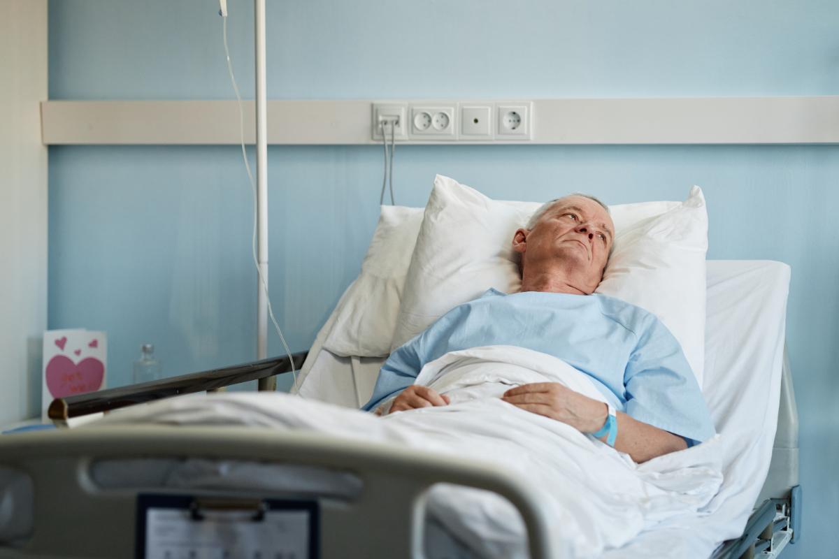 uomo a letto in ospedale