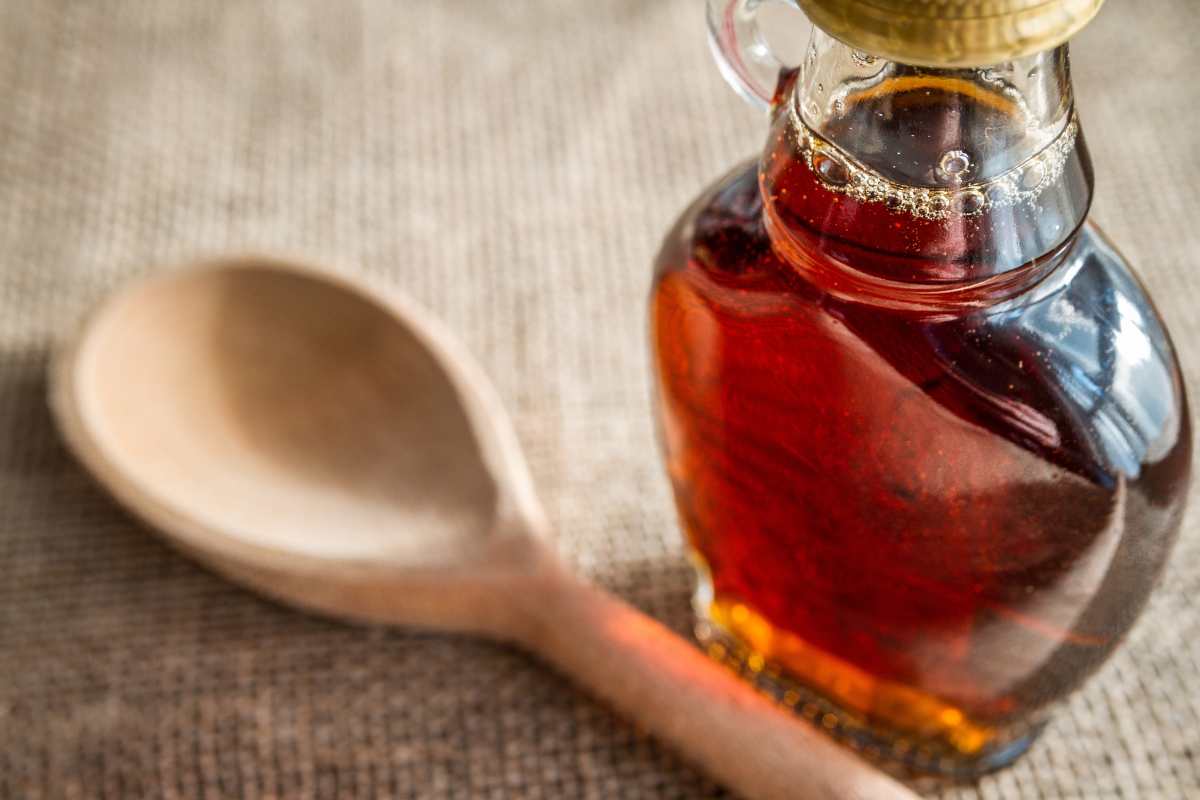 cucchiaino di legno e bottiglia sciroppo d'acero