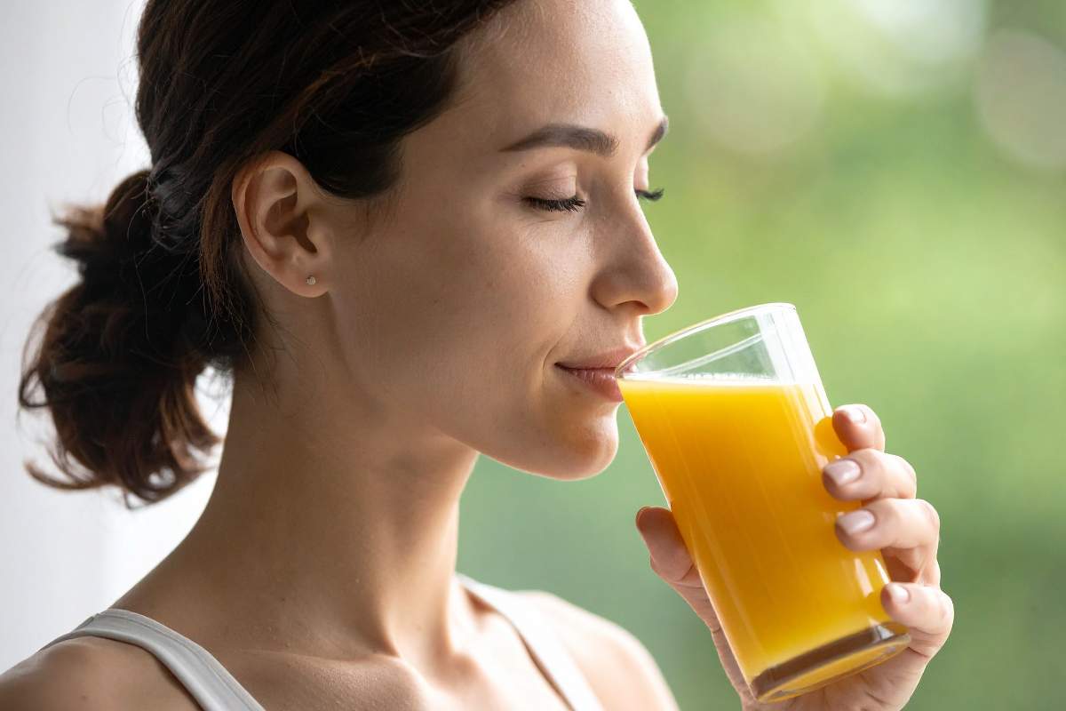 donna beve spremuta arancia